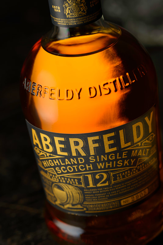 A tight shot of a bottle of Aberfeldy scotch whisky against a dark background.