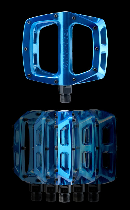 A group of blue bicycle pedals are displayed against a black background.