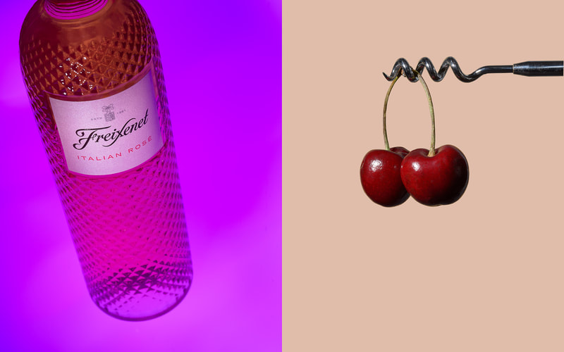 A pair of images that show a bottle of rose wine on the left and a pair of cherries hanging from a horizontal cork screw on the right.