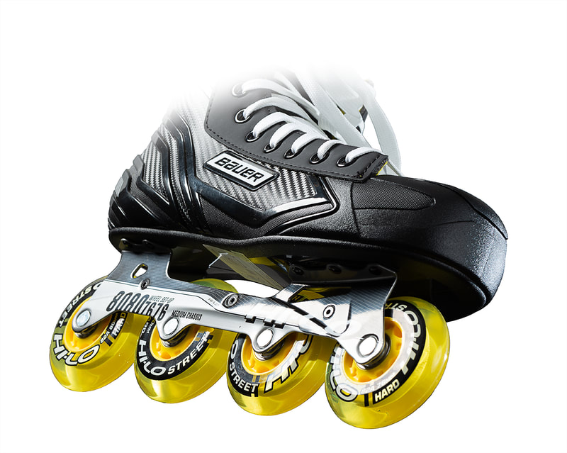 An inline skate with bright yellow wheels is angled against a stark white background. Shot by professional photographer Michael Taylor.