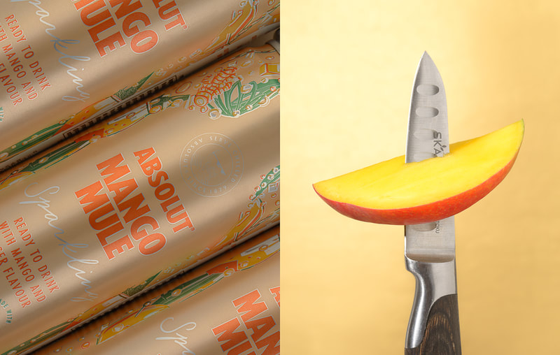 A pair of images with one on the left being a top view of 3 Absolute Mango Mule cans in gold tone, while on the right is an image of a small knife piercing a slice of yellow mango in front of a golden toned paper background.