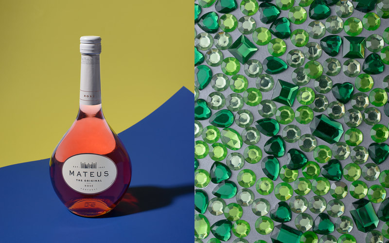 A pair of images show on the left a bottle pink wine sitting on a blue surface with a yellow wall behind. On the right is a top down view of a scattering of green plastic rhinestones on a grey surface. They glisten in the light.